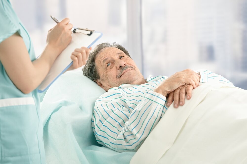 Les soins transatlantiques. Infirmière tenant un clipboard prenant des notes d'un patient âgé.